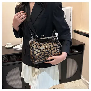 Détail d'un sac à main vintage en cuir noir avec paillettes dorées et fermoir métallique