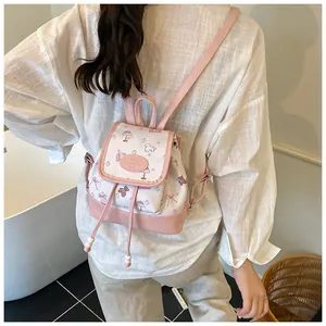 Rear view of floral mini bucket backpack with pink leather trim shown on a model