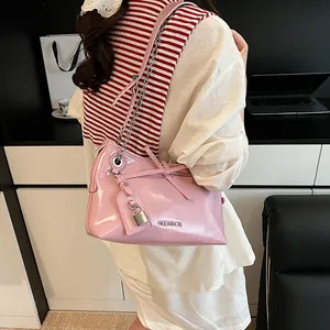 Pink patent leather tote bag with silver chain strap and metal lock detail shown on shoulder