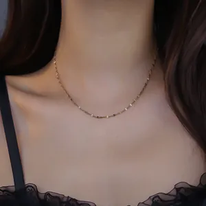 Close-up of a delicate 18K gold-plated lip chain necklace worn by a model