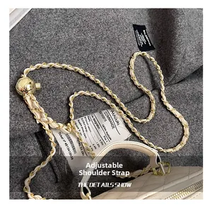 Detalle de hebilla de bola dorada ajustable y cadena de cuero en bolso beige acolchado