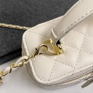 Detalle de bolso de cuero acolchado beige con gancho de metal dorado y correa de cadena