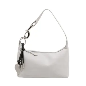 Chic light gray semi-moon underarm bag with silver heart pendant and woven tassel detail