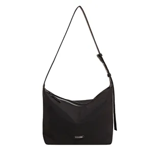 Large black nylon shoulder bag with adjustable strap and logo detail on white background
