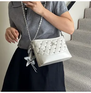 Detailed view of quilted white shoulder bag with silver star hardware and star charm