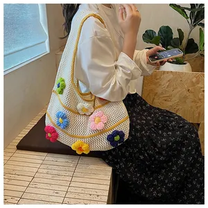 Detail of white hollow crochet tote bag featuring 3D colorful knit flowers and yellow trim