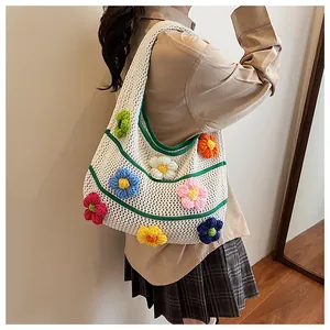 Detail of 3D knit flowers on a white crochet tote bag with artisan floral embroidery