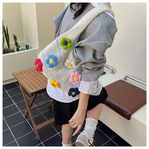 Detailed close-up of woven hollow tote bag with colorful 3D crochet flower ornaments