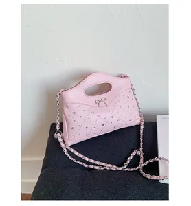 Detail of pink quilted leather bag with sparkling rhinestones and metal bow accent