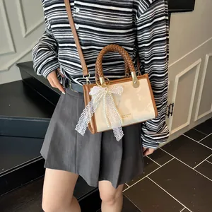 Retro crossbody bag with woven handle and lace bow detail shown on a model