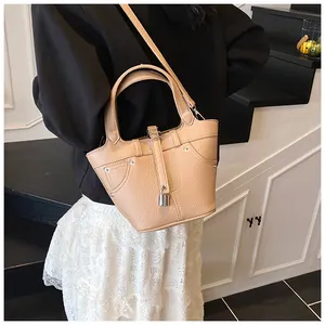 Détail du sac seau en cuir grainé avec clous argentés et pendentif cadenas métallique