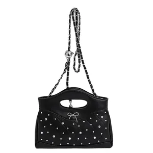 Black quilted crossbody bag with silver bow accent and adjustable chain strap