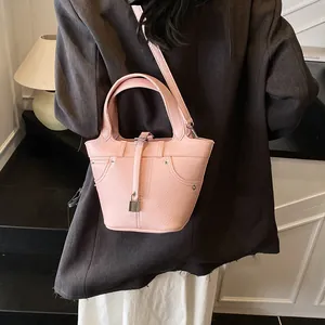 Sac seau rose pour femme en cuir litchi avec bandoulière et boucle métallique chic