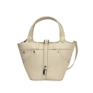 Sac seau minimaliste en cuir beige avec rivets métalliques et breloque cadenas élégante