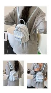 Detail shot of light blue gingham mini backpack with adjustable straps and zipper pockets