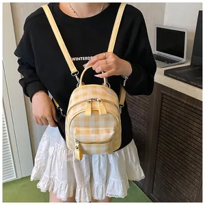 Close-up of yellow and white gingham mini backpack with adjustable straps and gold zippers