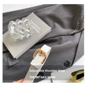 Detail of white leather adjustable shoulder strap with golden metal buckle and stitching