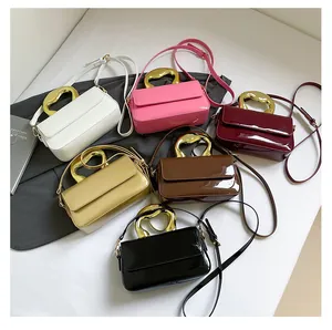 Close-up of glossy patent leather handbags with stylish gold-tone metal handles