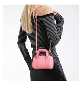 Detail of pink mini Boston bag with litchi texture and silver fashion text lettering