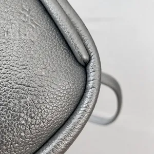 Close-up of silver pebble grain leather texture and fine stitching on a trendy backpack