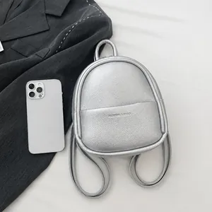 Macro view of silver litchi grain mini backpack with phone for size comparison