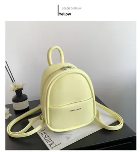 Macro view of textured yellow leather mini backpack with dual zippers and front pocket