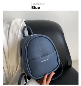 Detail of blue lychee grain leather mini backpack on a black seat showing texture