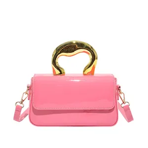 Pink patent leather crossbody bag with artistic gold metal handle and long strap