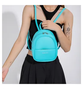 Detail of lake blue mini backpack showing litchi grain texture and silver zippers
