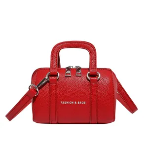 Red mini Boston bag in lychee texture leather with top handles and shoulder strap