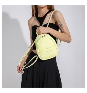 Detail of light yellow mini backpack with litchi texture and silver zipper detail