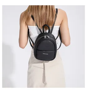 Rear view of model wearing a black mini egg-shaped backpack with lychee leather texture
