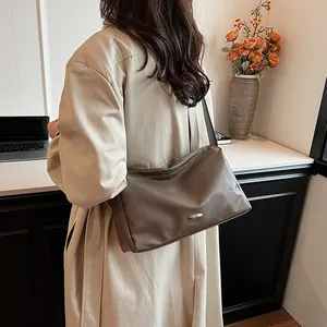 Minimalist vintage hobo bag in dark khaki leather shown on shoulder for daily commute