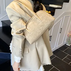 Elegant beige vintage baguette bag in textured suede with double handles and topstitching