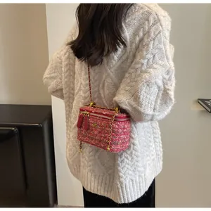 Détails du tweed rose et chaîne dorée sur un sac boîte avec fermoir floral chic