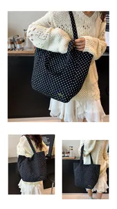 Dettaglio della borsa tote a pois neri e bianchi con logo in metallo dorato e tracolla