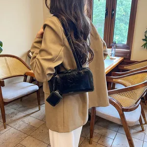 Retro black leather shoulder bag with a mini pouch accessory for a stylish autumn look