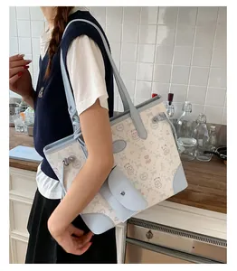 Detail of color-block tote bag with cartoon bear prints shown in a home setting