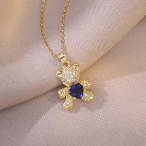 Collier en acier titane doré avec pendentif ourson et zircon bleu en forme de cœur