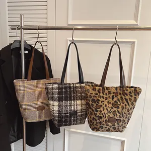 Three large casual tote bags in leopard print and plaid textures hanging on a rack