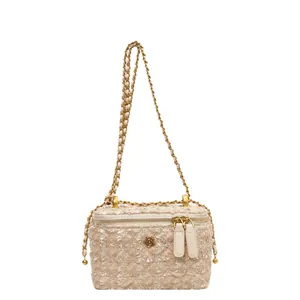 Sac bandoulière en tweed rose et beige avec chaîne dorée et logo floral élégant