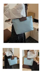 Dettaglio della borsa tote azzurra in tessuto Oxford con patta marrone e logo