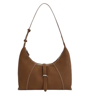 Brown leather crescent underarm bag with white contrast stitching and metal buckle details