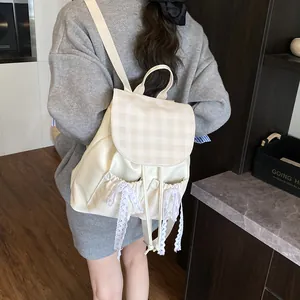 Minimalist cream backpack with plaid flap and lace bows shown from a side view