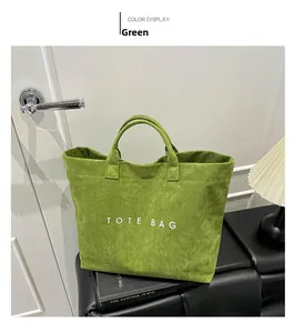 Dettaglio della borsa tote verde con scritta TOTE BAG bianca su panca in pelle