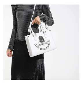White shoulder bag featuring silver rivet studs and a 3D skull motif on leather surface