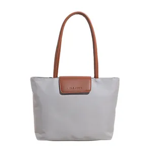 Borsa tote grigia minimalista con manici in pelle marrone e logo CLEARSK su sfondo bianco