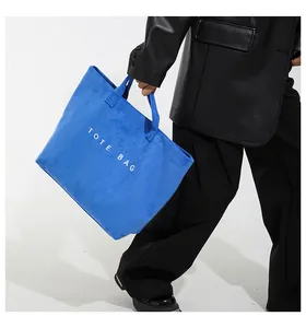 Dettaglio della borsa tote in peluche blu acceso con testo TOTE BAG ricamato bianco