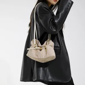 Borsa a secchiello minimalista beige in pelle scamosciata con coulisse e dettagli oro