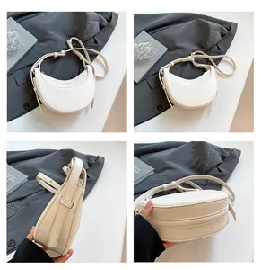 Détails du sac demi-lune blanc cassé montrant le cuir grainé et le logo FASHION argenté